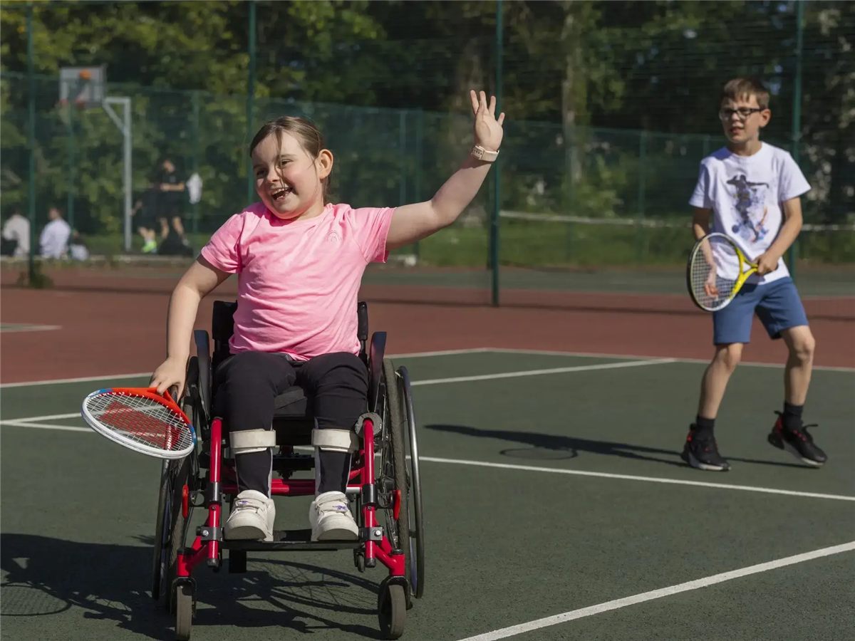 A girl in a wheelchair playing tennis