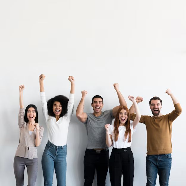 A group of young people cheering with their arms raised