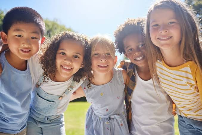 A group of smiling children with their arms around each other